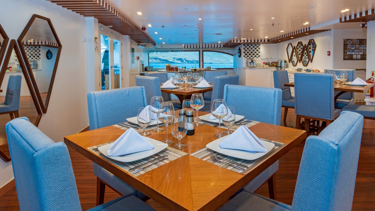 Indoor dining area with tables set up ready for guests on a small luxury cruise ship