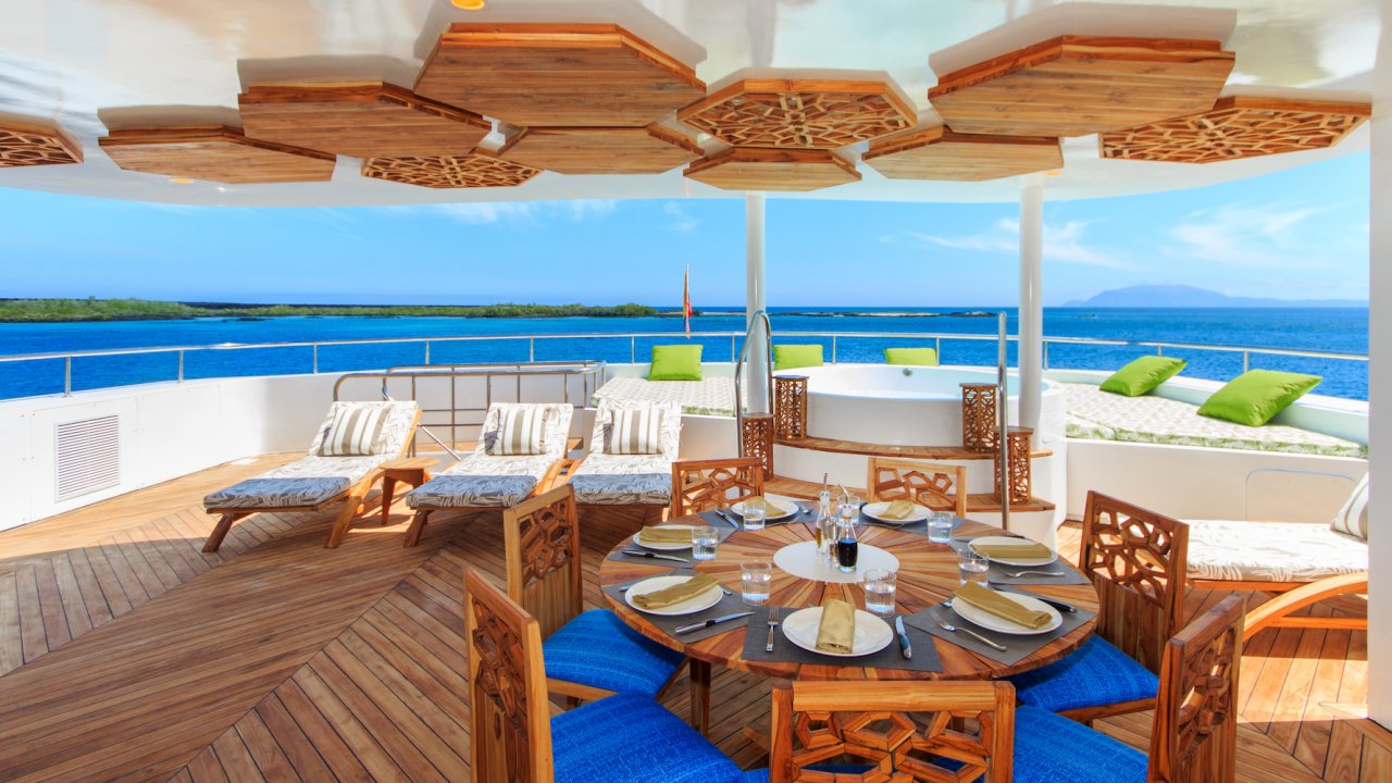 Outdoor dining area on the top of a small luxury chartered catamaran ship