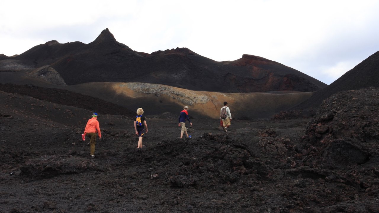 Four people hiking on a volcano in the Galapagos