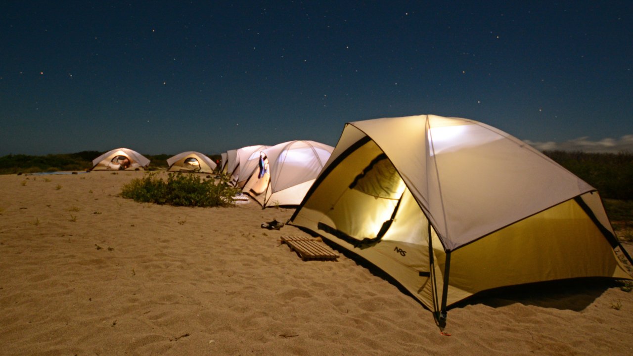 A row of tents set up on the beach in the Galapagos Islands at night