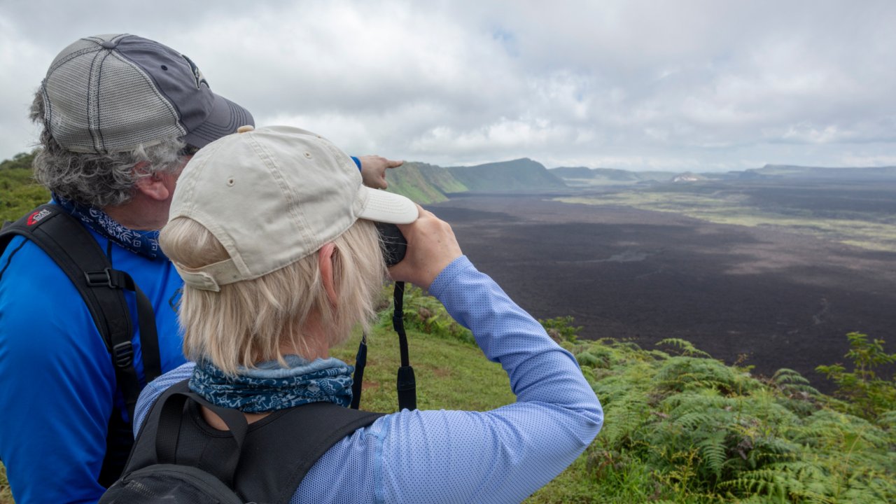 A man taking a picture of the Sierra Negra from an overlook in the Galapagos