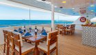 Outdoor dining area on the top of a small luxury cruise ship on a sunny day in the Galapagos