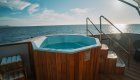 Wood paneled jacuzzi hot tub on board a small luxury cruise at sunset