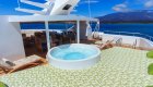 Jacuzzi on the sun deck of a small yacht with room to lounge on a sunny day
