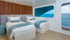 Two freshly made twin beds in a stateroom cabin aboard a small luxury yacht in the Galapagos Islands