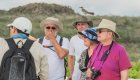 A group of people gathered together listening to their guide on a hike in the Galapagos
