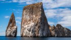 Dramatic cliffs of Kicker Rock rising from the ocean under blue skies, a highlight stop on many Galapagos family vacations.