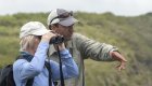 A couple standing and looking at something with binoculars