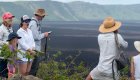 Group of tourists all wearing hats hiking on Sierra Negra Volcano in Galapagos Islands